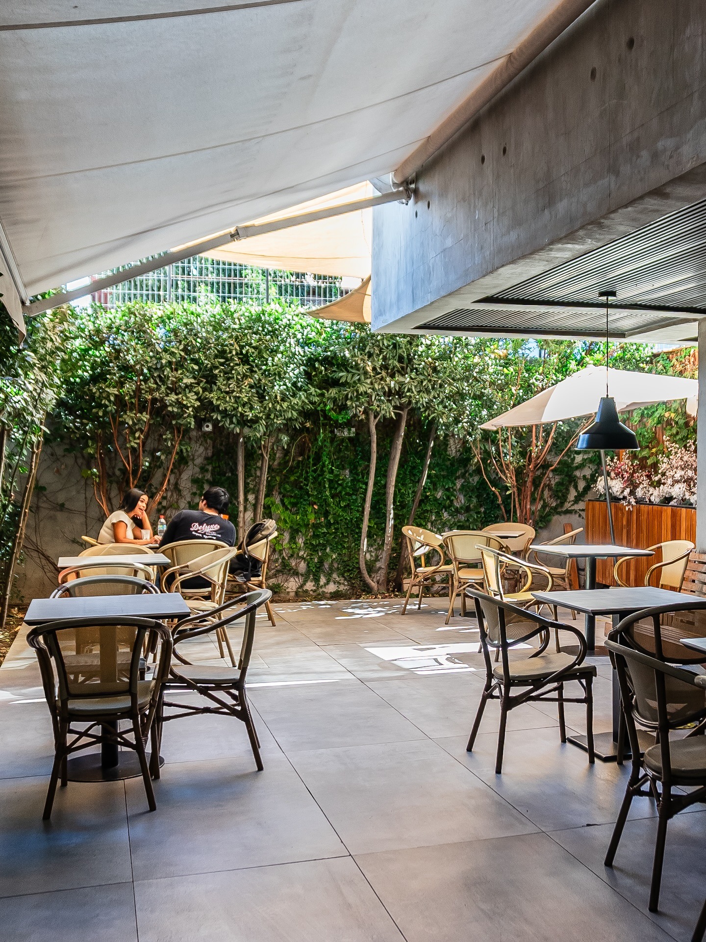 Terraza interior de Raconto Los Andes con muro verde y toldos