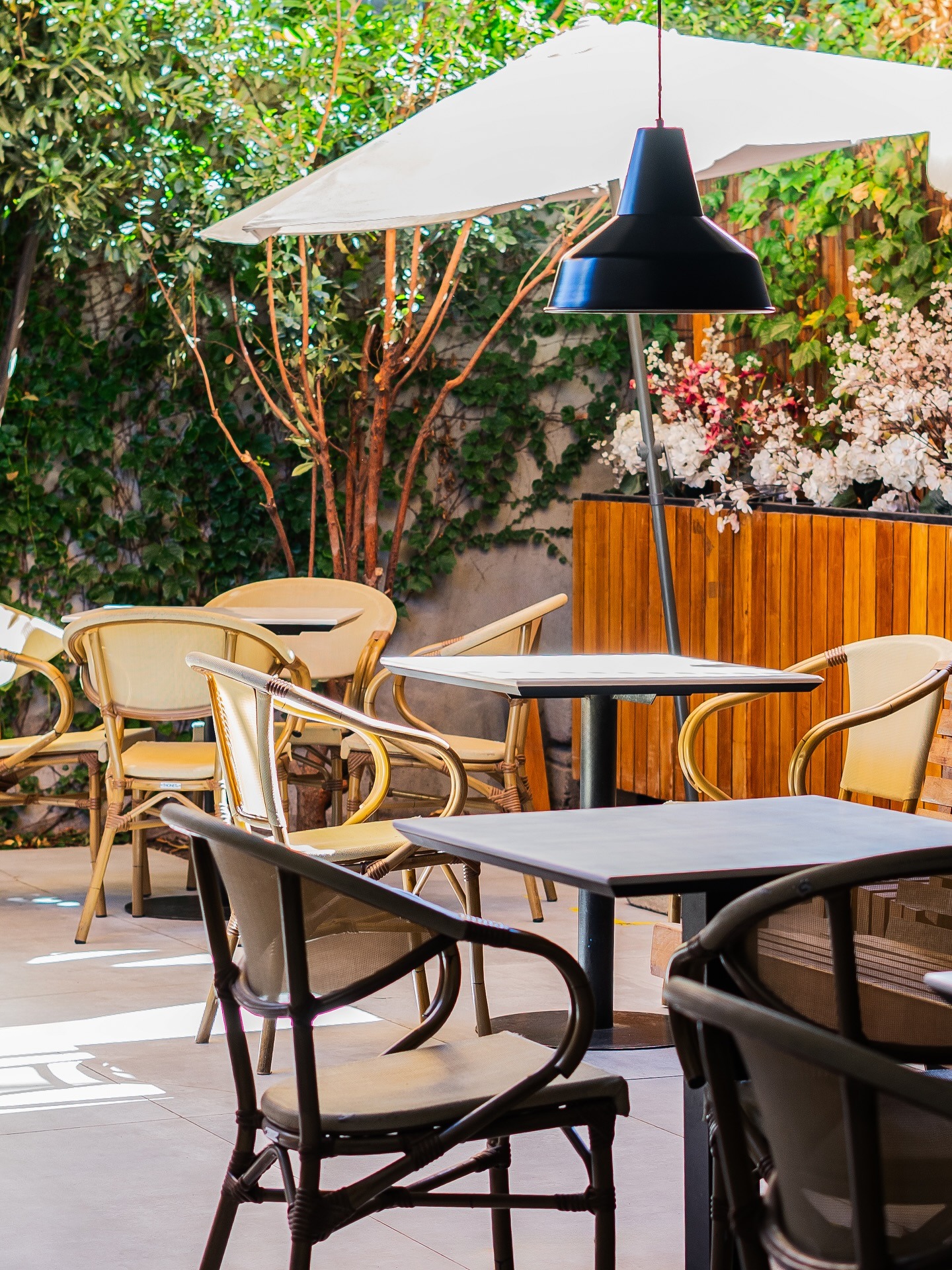 Terraza de Raconto Los Andes con quitasoles y flores