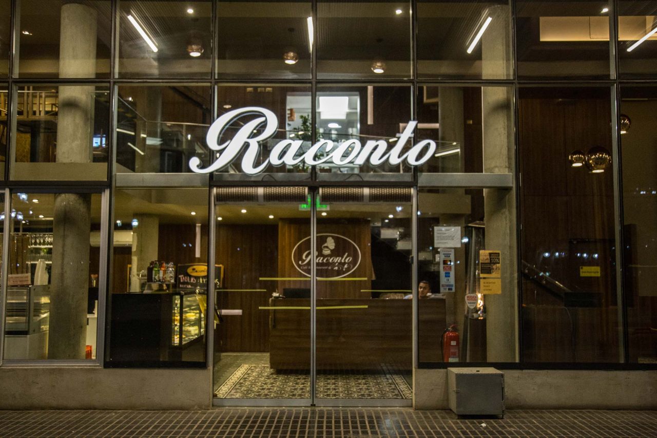 Fachada de Raconto Café Restaurant iluminada de noche